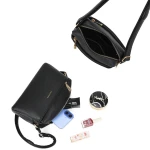 Wnętrze małej czarnej torebki z telefonem i kosmetykami pokazujące dużą pojemność